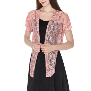Detailed view of women's pink floral lace cardigan bolero shawl paired with black dress