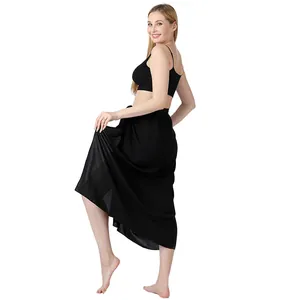 Ganzkörper-Seitenansicht eines Models im schwarzen einfarbigen Strand-Sarong-Wickelrock