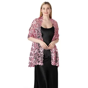 Dettaglio di uno scialle rosa ricamato con paillettes floreali su abito da sera nero
