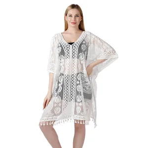 Detailopname van een elegante witte kant strand cover-up met bloemenpatroon en franjes