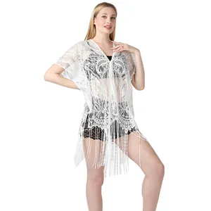 Detalle de pareo de encaje blanco con diseño de cachemira y borlas largas de moda