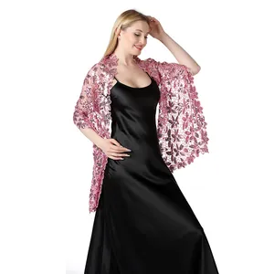 Dettaglio dello scialle rosa ricamato con paillettes su abito da sera.
