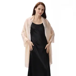 Elegante chal de noche arrugado brillante champán con un vestido largo de satén negro.