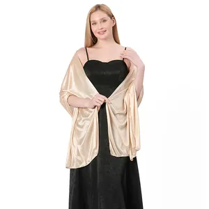 Detailed view of elegant champagne gold satin shawl draped over black evening dress