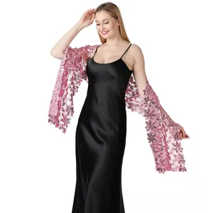 Elegante scialle di pizzo con paillettes rosa drappeggiato su un abito da sera in raso nero