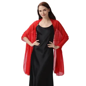 Elegante chal rojo metalizado transparente combinado con un vestido de satén negro