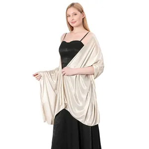 Detailed view of elegant champagne satin shawl worn by a model over a black dress