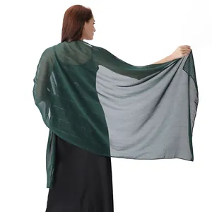 Detailed view of green chiffon shawl with silver threads and rhinestone accents