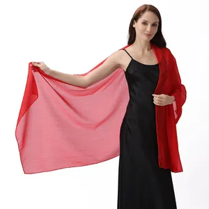 Textura detallada del chal de crepé de seda rojo brillante sobre vestido de gala