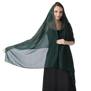 Detailed view of dark green chiffon shawl featuring silver threads and shimmering rhinestones