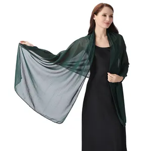 Detail view of dark green chiffon shawl with shimmering silver thread and rhinestones