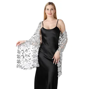 Dettaglio di scialle in pizzo argentato con paillettes scintillanti indossato da modella