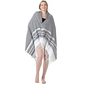 Toalla de playa turca gris con rayas blancas y flecos de algodón envuelta en una modelo.