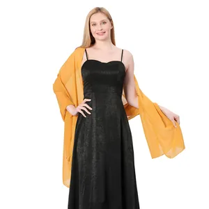 Detailed view of yellow chiffon shawl draped over a black evening dress