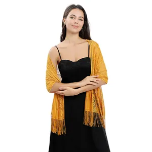 Close-up of yellow floral lace shawl with long fringe on a model in a black dress