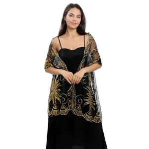 Detailed view of black sheer shawl with intricate gold sequined embroidery and fringe.