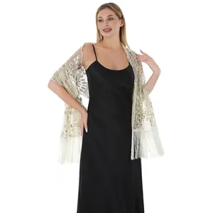 Detail view of elegant gold sequin peacock embroidered tassel shawl worn on a black dress