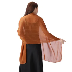 Detail showing the sheer texture of the orange chiffon shawl with silver thread and rhinestones.