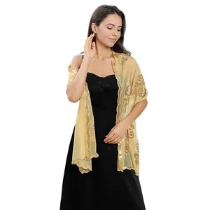 Elegant gold sequin shawl with peony embroidery draped over a black evening dress