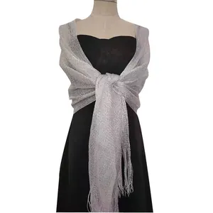 Shimmering silver metallic shawl with fringe detail draped over a black evening gown.