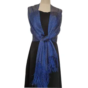 Detailed view of a sparkling blue Lurex evening shawl with fringes on a black dress.