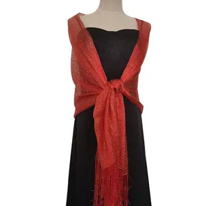 Macro view of red metallic shimmering shawl with elegant fringe and knotted drape