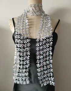 Close-up detail of a silver sequin decorative scarf with star patterns on a mannequin