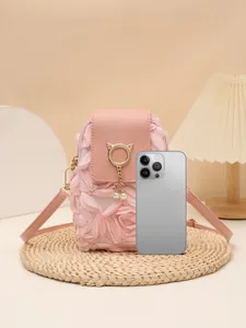 Detalle que muestra la comparación de tamaño del bolso rosa de pétalos con smartphone