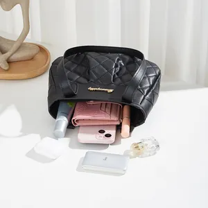 Black quilted faux leather shoulder bag showing storage capacity with everyday essentials