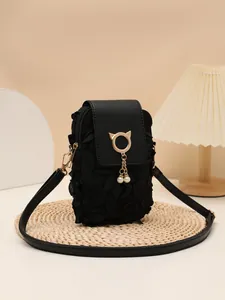 Elegante bolso bandolera vertical negro con un colgante de gato dorado y perlas