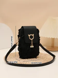 Detalle del bolso bandolera negro con flores 3D, colgante de gato dorado y perlas