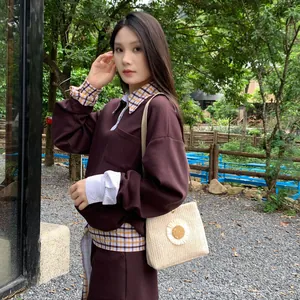 Chic straw woven crossbody bag featuring a large daisy flower charm, shown on female model