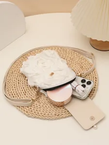 Vista detallada del bolso bandolera blanco con flores que muestra su capacidad