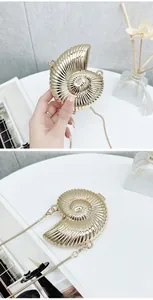 Macro detail of luxury golden conch shell shaped mini evening bag with a metal chain strap