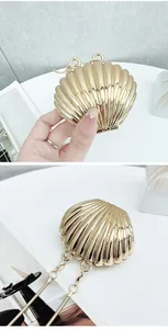 Detail of gold shell-shaped mini acrylic handbag with metallic chain for kids