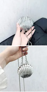 Detail view of the metallic silver shell-shaped acrylic mini bag with chain strap