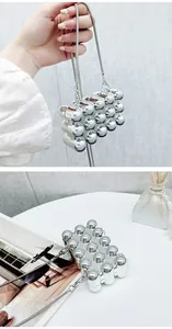 Detailed view of the silver acrylic mini bag featuring a unique capsule textured design