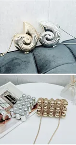 Detail view of metallic shell-shaped and bubble-textured mini clutch bags with chains.
