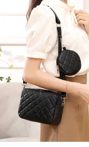 Vista dettagliata della borsa a tracolla trapuntata nera con portamonete tondo su modella