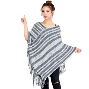 Vista detallada del poncho de punto a rayas grises y blancas con dobladillo de flecos