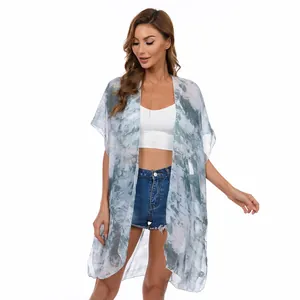Kimono playero de gasa tie-dye sobre top corto blanco y pantalones vaqueros