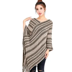 Vista detallada de poncho de punto a rayas con adornos de borlas en modelo asiática