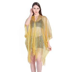 Detailed macro view of a gold metallic mesh bikini cover-up featuring a delicate fringe hem