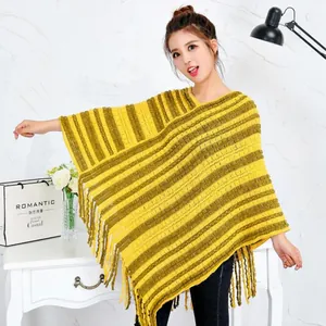 Modelo femenina mostrando un poncho de punto a rayas amarillas y verdes con flecos