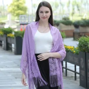 Elegant purple lace shawl scarf with floral pattern and fringe details on a female model.