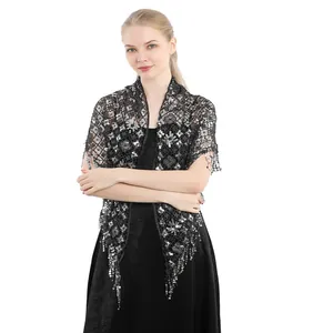 Detailed view of a black lace bridal shawl with silver sequins and fringe tassels
