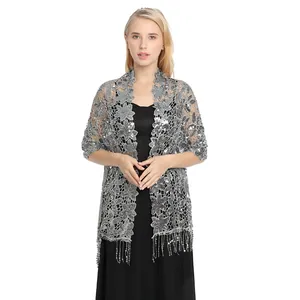 Detailed view of an elegant silver sequin floral lace shawl with long tassels on a model