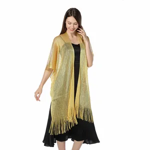Elegant gold metallic thread shawl with long fringe worn over a black evening dress