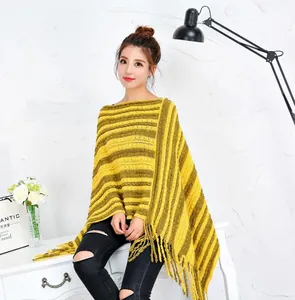Detalle del poncho de punto a rayas con flecos suaves y textura elegante.