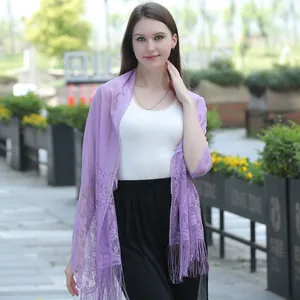 Elegant purple lace shawl scarf with fringe details worn by a model in an outdoor park